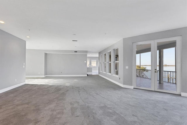 carpeted empty room with plenty of natural light and french doors