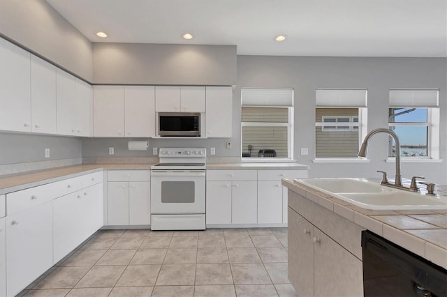 kitchen featuring electric stove, white cabinetry, dishwasher, and sink