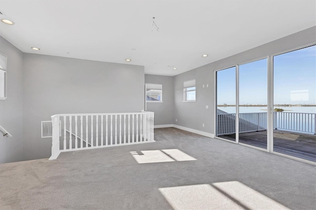 carpeted spare room featuring a water view