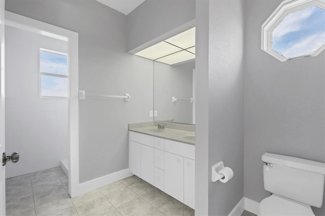 bathroom with tile patterned flooring, vanity, and toilet