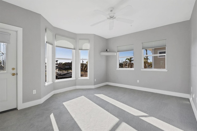 empty room with ceiling fan and light carpet