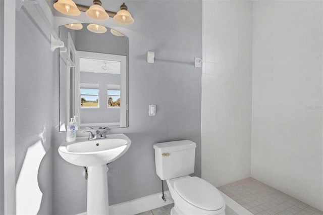 bathroom featuring tiled shower and toilet