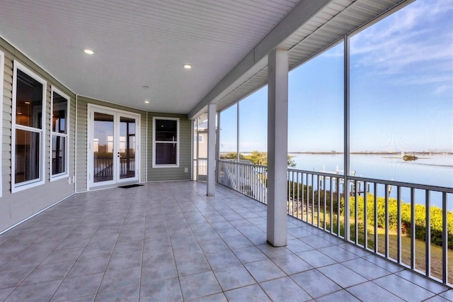 unfurnished sunroom featuring a water view