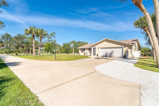 single story home featuring stucco siding, fence, a garage, driveway, and a front lawn