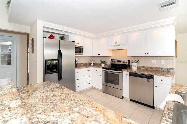 kitchen with under cabinet range hood, stainless steel appliances, visible vents, white cabinets, and tasteful backsplash