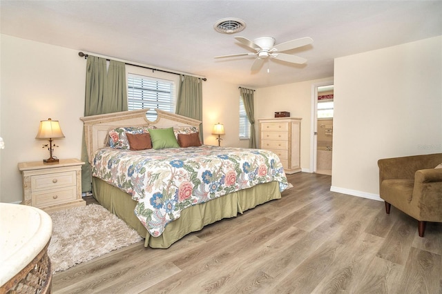 bedroom with ceiling fan, wood finished floors, visible vents, and baseboards