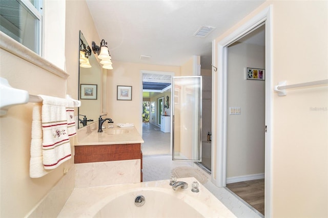 full bath with vanity, visible vents, baseboards, a bath, and a stall shower