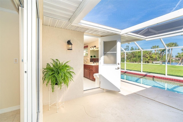 view of swimming pool with a lanai, a patio area, and a sink