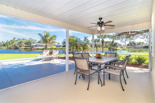 sunroom / solarium featuring a water view, a ceiling fan, and a healthy amount of sunlight