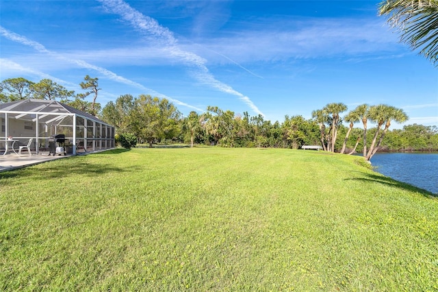 view of yard with a lanai and a water view