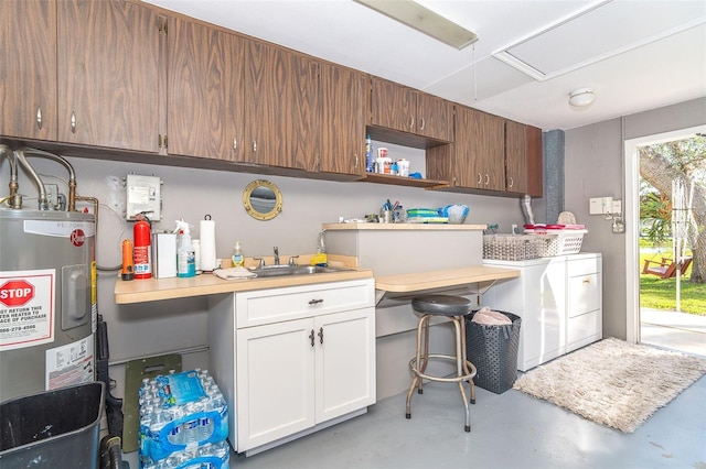 laundry room with a sink, water heater, cabinet space, washing machine and clothes dryer, and attic access