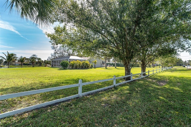 view of yard featuring glass enclosure and fence