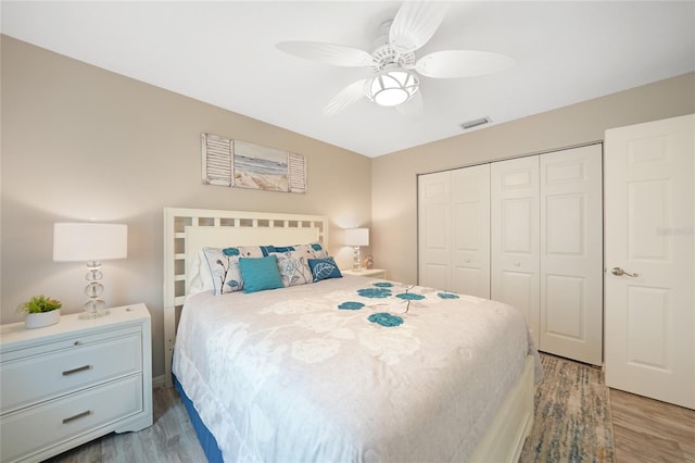 bedroom with hardwood / wood-style floors, a closet, and ceiling fan