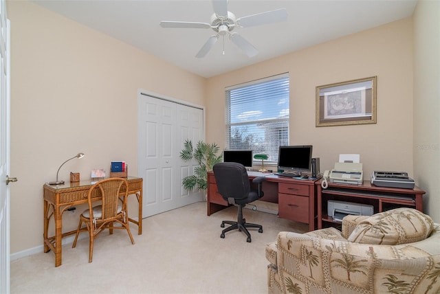 carpeted home office featuring ceiling fan