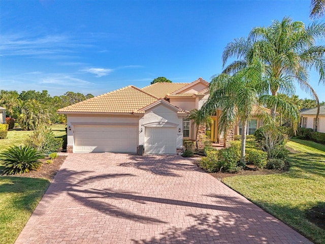 mediterranean / spanish-style house featuring a garage and a front lawn