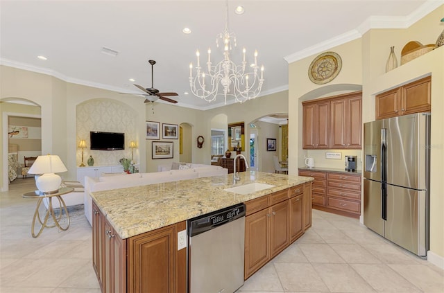 kitchen with sink, light stone counters, decorative light fixtures, a center island with sink, and appliances with stainless steel finishes