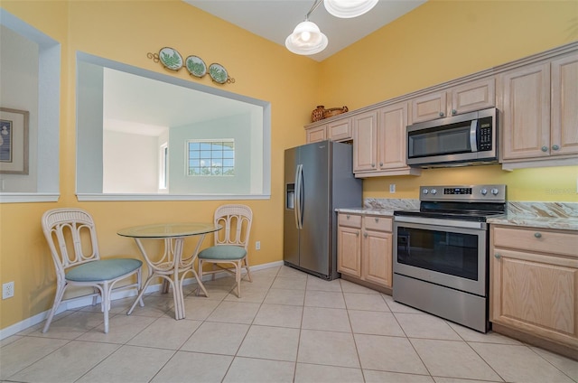 kitchen with light stone counters, appliances with stainless steel finishes, light tile patterned floors, and light brown cabinets