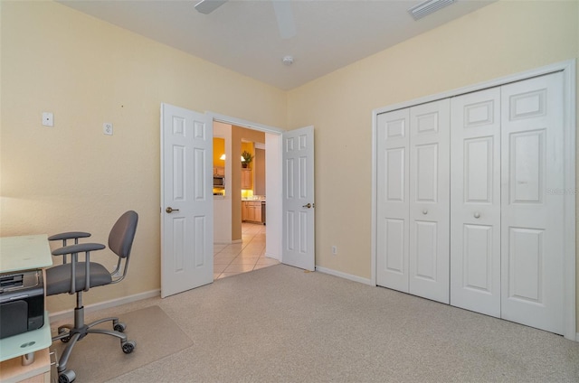 carpeted office space featuring ceiling fan