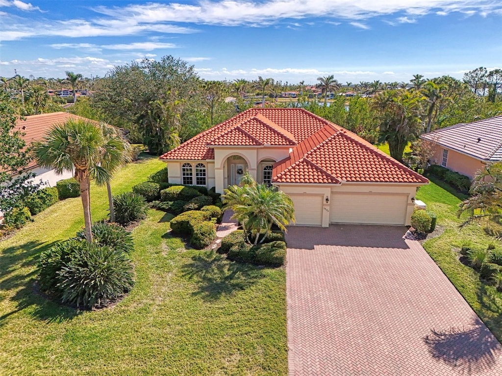 mediterranean / spanish-style house featuring a garage and a front lawn