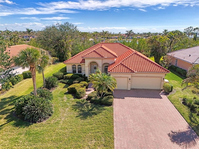 mediterranean / spanish-style house featuring a garage and a front lawn