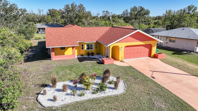 single story home featuring a garage and a front lawn