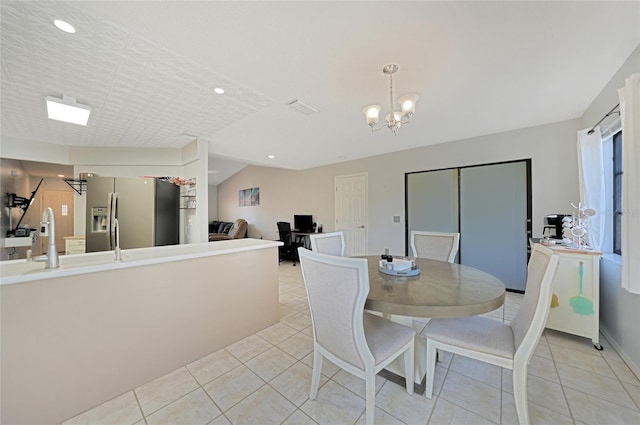 dining area featuring sink, light tile patterned floors, and an inviting chandelier