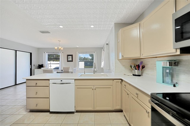 kitchen featuring sink, light tile patterned floors, white dishwasher, kitchen peninsula, and decorative backsplash