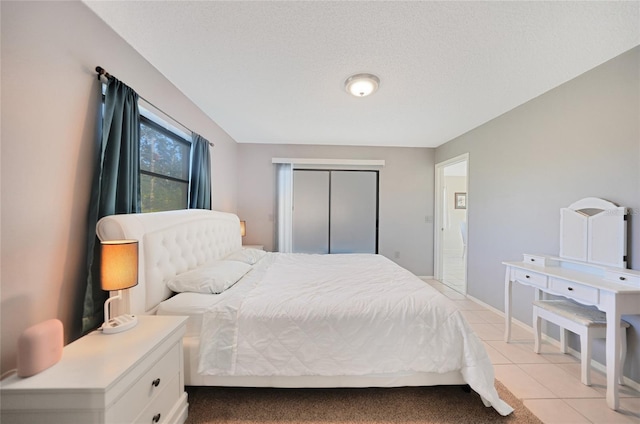 tiled bedroom featuring a closet and a textured ceiling