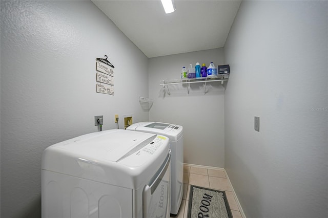 clothes washing area featuring tile patterned flooring and independent washer and dryer