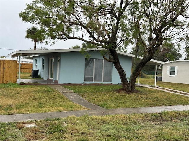 view of front facade featuring cooling unit, a front yard, and a carport