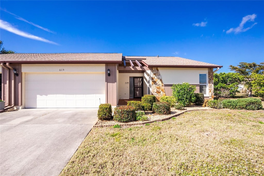 single story home featuring a garage and a front yard