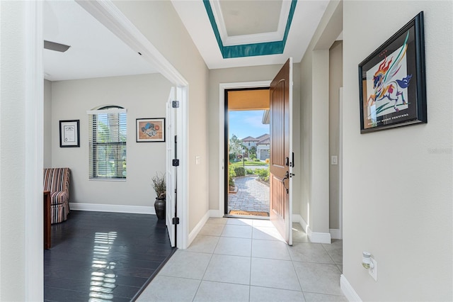 entrance foyer with light tile patterned floors and a raised ceiling