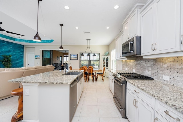 kitchen featuring white cabinetry, stainless steel appliances, sink, and a center island with sink