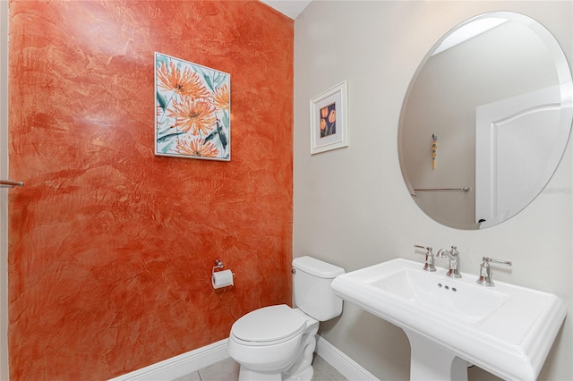 bathroom featuring toilet, tile patterned flooring, and sink