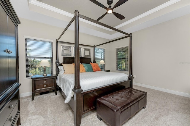 bedroom featuring ornamental molding, light colored carpet, and a raised ceiling