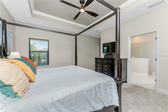 carpeted bedroom with crown molding, ceiling fan, ensuite bathroom, and a raised ceiling