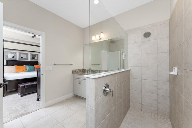 bathroom featuring tiled shower, vanity, and tile patterned flooring