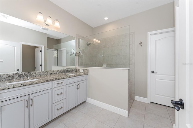 bathroom featuring tiled shower, tile patterned floors, and vanity