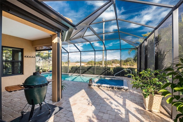 view of pool featuring grilling area, a patio area, and glass enclosure