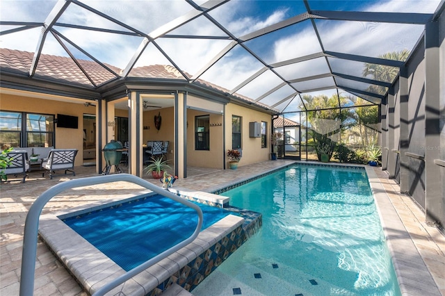 view of swimming pool featuring an in ground hot tub, ceiling fan, a lanai, and a patio