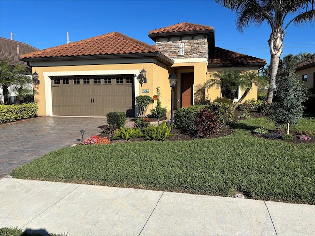 mediterranean / spanish-style house with a garage and a front lawn