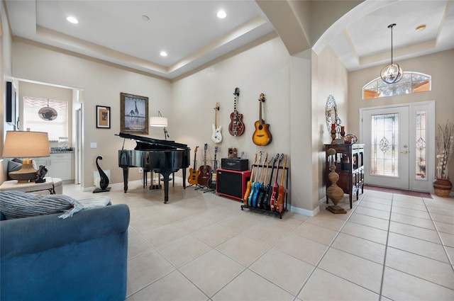 tiled entryway with a notable chandelier and a tray ceiling