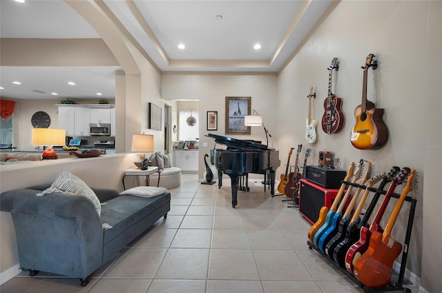 living room with a raised ceiling and light tile patterned floors