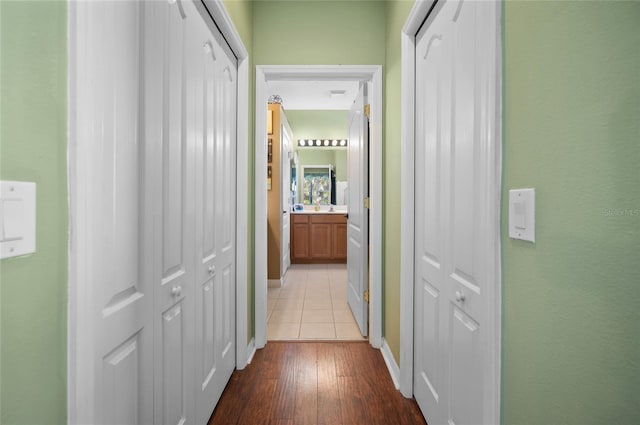 corridor featuring sink and light hardwood / wood-style flooring