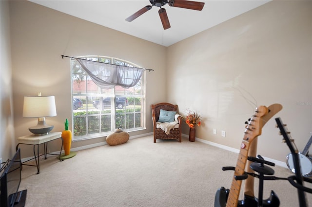 sitting room with ceiling fan and carpet flooring