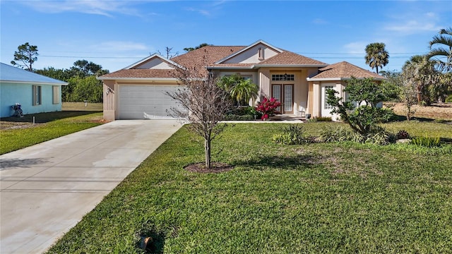 411 Boundary Blvd, Rotonda West, FL 33947 - view of front of home featuring a front lawn, concrete driveway, stucco siding, and an attached garage
