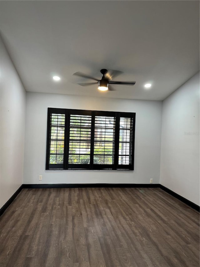 empty room with dark hardwood / wood-style floors and ceiling fan