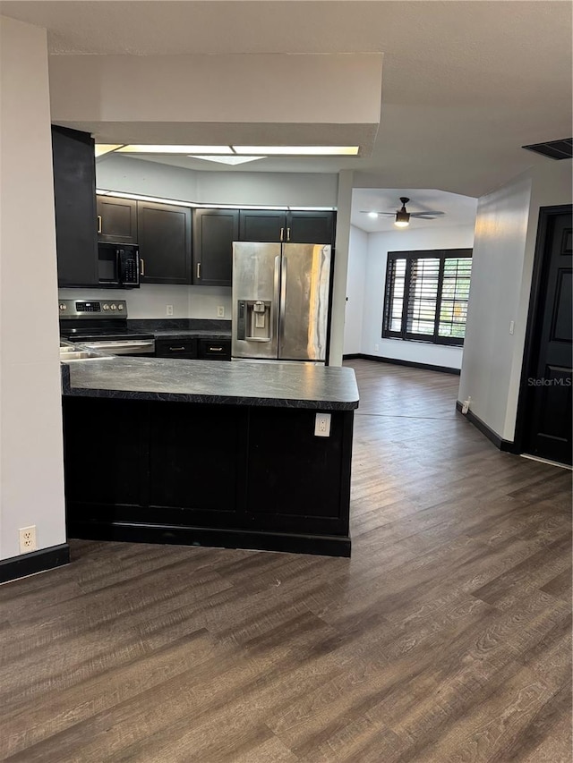 kitchen featuring stainless steel appliances, dark hardwood / wood-style floors, ceiling fan, and kitchen peninsula