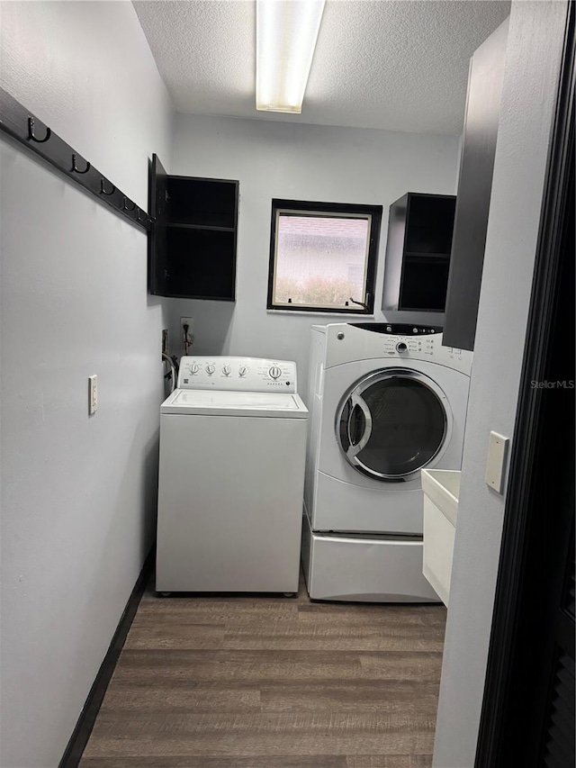 washroom featuring dark hardwood / wood-style flooring, separate washer and dryer, and a textured ceiling