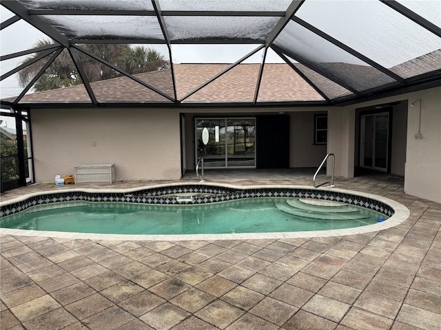 view of pool with a patio and glass enclosure